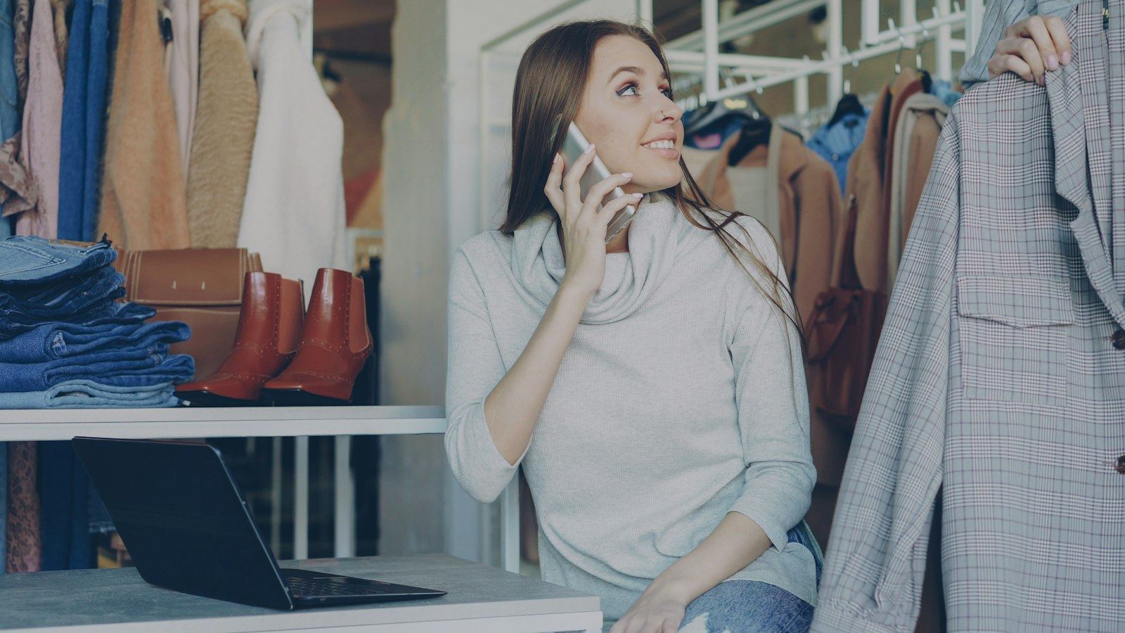 A shop owner answering a customer on her phone